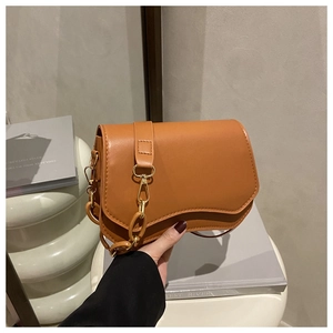 Close-up of tan PU leather shoulder bag with unique wavy base and resin chain detail