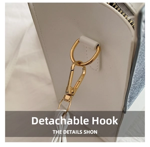Detailed close-up of golden metal detachable hook on white leather small square bag