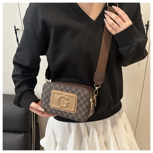 Gros plan du sac bandoulière marron avec motif monogramme et détails dorés chics