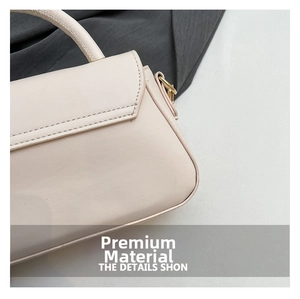 Detail view of cream leather handbag showing precise stitching and gold D-ring hardware