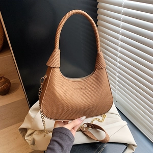 Retro brown woven crescent shoulder bag with gold chain and handle in natural light