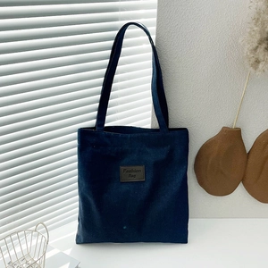 Sac fourre-tout en denim bleu foncé avec étiquette en cuir et design minimaliste