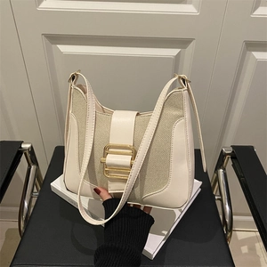 Retro cream white leather shoulder bag with vintage gold buckle on a stylish book