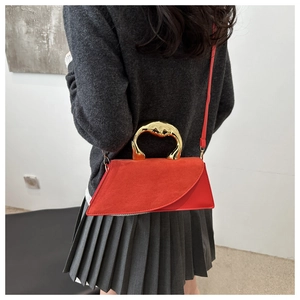 Vue détaillée d'un sac à main géométrique rouge avec poignée artistique en métal doré