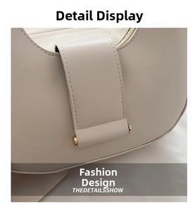 Detail of off-white faux leather handbag featuring folded flap and gold cylinder hardware