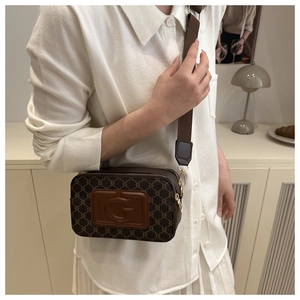 Détail du sac bandoulière marron vintage avec logo G embossé et large bandoulière
