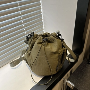 Army green nylon drawstring bucket bag with side mesh pocket and adjustable shoulder strap