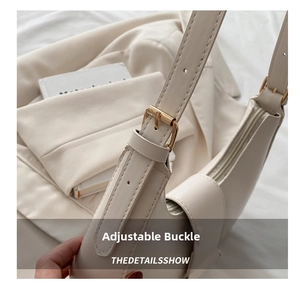 Detail of adjustable gold buckle and fine cream leather on a French retro shoulder bag