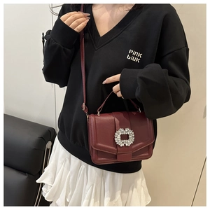 Close-up of wine red crossbody bag with lychee texture leather and crystal buckle