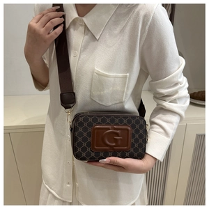 Détail d'un sac caméra vintage en toile monogramme avec logo G embossé et détails dorés