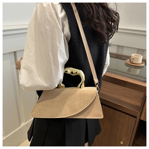 Detail showing high-quality beige suede stitching and art-style gold metal handle