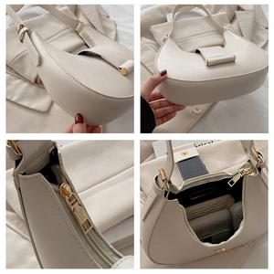 Macro details of beige crescent hobo bag showing zipper and adjustable shoulder strap