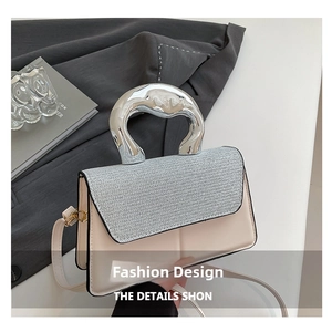 Détail du sac à main élégant avec panneau contrasté et poignée sculptée en métal