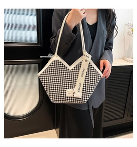 Detail of houndstock tote bag with V-cut top edge and fashion strap shown by a model
