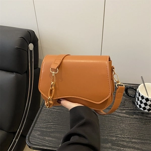 Minimalist brown leather underarm shoulder bag with gold buckle and chain strap
