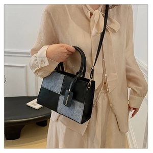 Detail of checkered patchwork handbag featuring grey denim and black leather textures