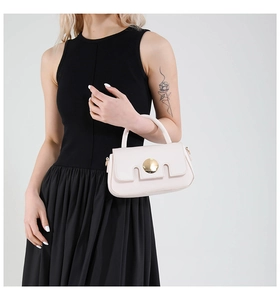 Détail d'un mini sac à main élégant en cuir crème avec un fermoir doré en métal
