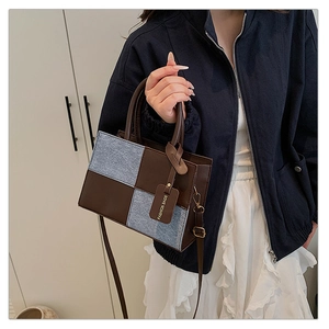 Detail of retro patchwork handbag showing brown leather and blue denim fabric textures