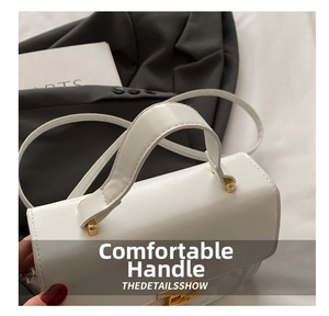 Macro detail of the golden clasp and stitching on white leather tote bag