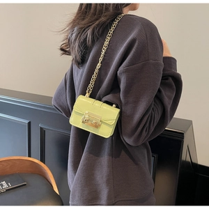 Mini sac bandoulière vert citron avec chaîne dorée porté par un mannequin de profil