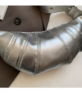 Macro view of silver metallic croissant bag showing quilted stitching and crinkled texture