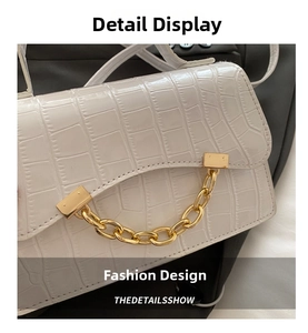 Close-up of white crocodile pattern handbag with luxury gold chain and hardware