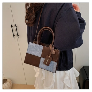 Detail view of stitched patchwork crossbody bag showing texture and fashion tag