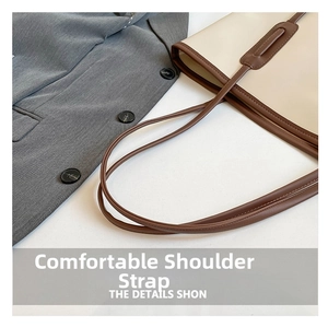 Close-up of durable long shoulder straps on a minimalist leather tote bag with fine stitching