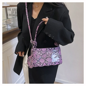 Détail d'un sac bandoulière violet à motif serpent et bords ondulés élégants