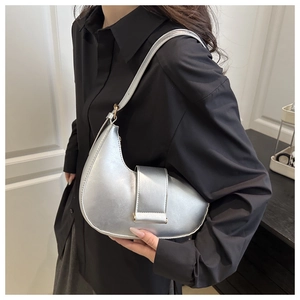 Detailed close-up of a silver crescent underarm bag with metallic faux leather texture