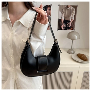 Detail of a black hobo underarm bag with gold buckle and adjustable leather strap