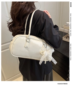 Boston bag detail showing cream leather texture and delicate lace pearl pendant