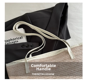 Close-up of the woven V-pattern texture and white leather handles on the tote bag