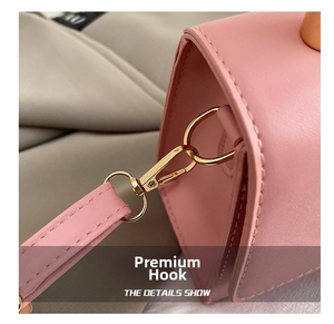 Detail of pink leather handbag showing fine stitching and premium gold metal hooks