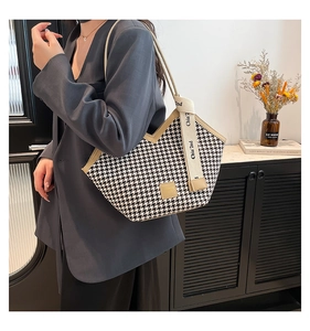 Detail of houndstooth tote bag featuring a V-shaped cut and branded wide strap