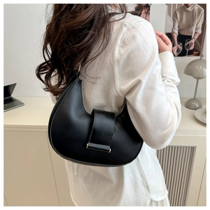 Elegant black leather crescent moon hobo bag worn by model in a minimalist setting