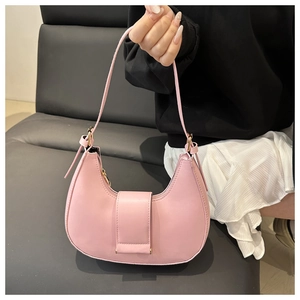 Detail of a pink crescent hobo bag made of smooth leather held by a model