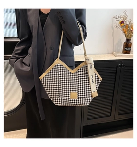 Close-up of houndstooth tote bag with beige leather trim and ribbon detail for women