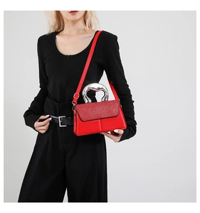 Détail d'un sac rouge élégant avec paillettes brillantes et poignée en métal argenté