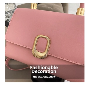 Close-up of pink leather handbag featuring a rippled gold metal buckle and neat stitching