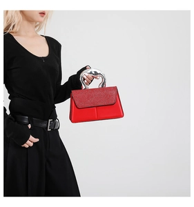 Détail du sac à main rouge avec rabat à paillettes et poignée en métal argenté