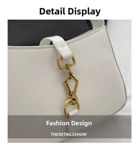 Close-up of the vintage gold piston clasp and white leather texture on the hobo bag