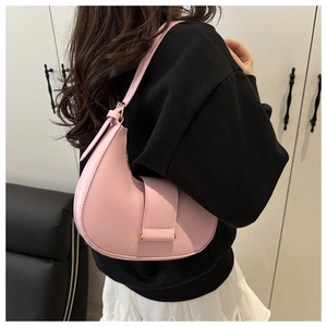 Close-up of pink crescent hobo bag with wide buckle strap and adjustable handle