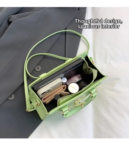 Spacious interior of a lime green patent leather handbag with multiple daily essentials