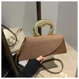 Detail of geometric brown suede bag with unique gold metallic handle and crossbody strap