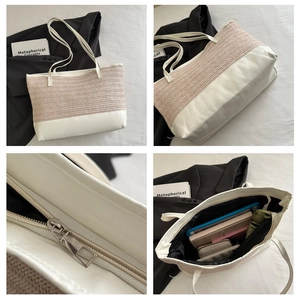 Detail of straw tote bag showing metal zipper closure and spacious interior compartment