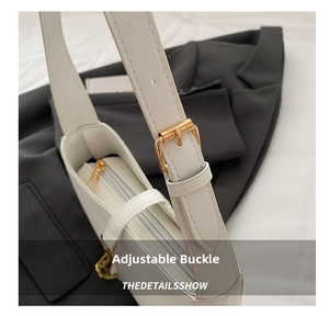 Detail showing adjustable strap with gold-tone buckle and zipper of white shoulder bag