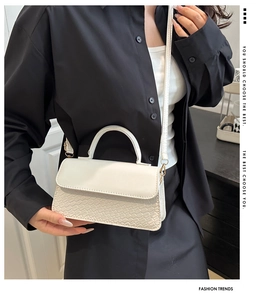 Detail of white minimalist handbag showing smooth fabric and embossed faux leather texture