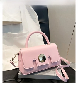 Detail of pink faux leather crossbody bag with silver mirror buckle on English books