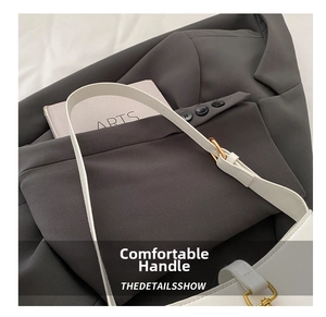 Detail of white leather shoulder strap with adjustable gold metal buckle and hardware